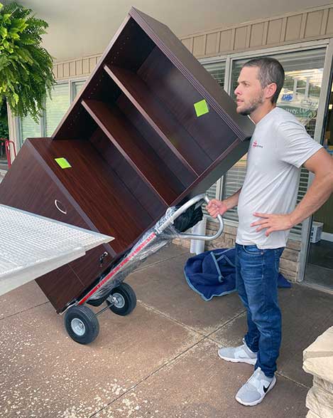 "Experienced mover transporting furniture with a dolly for residential and commercial moving services in Bowling Green."